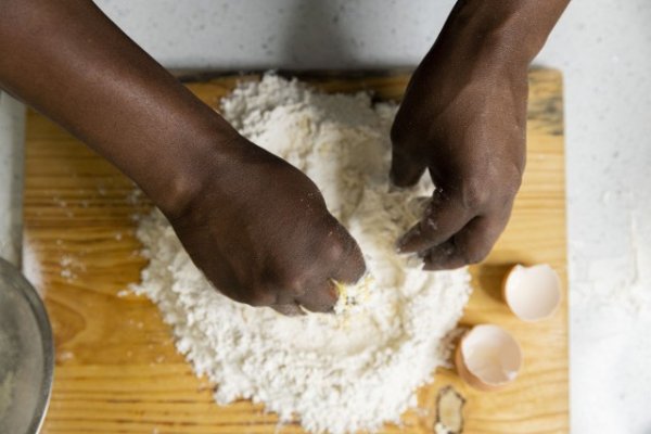 Cracking eggs inside flour