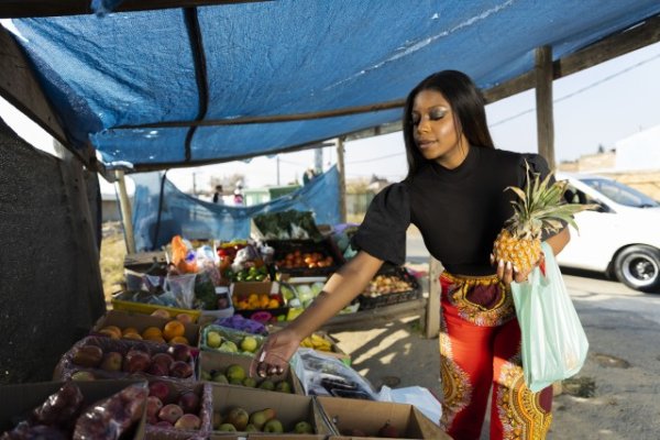 Black woman buying fruits at the local market