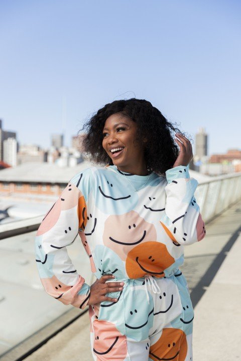 Black woman on Nelson Mandela bridge smiling with colourful clothing
