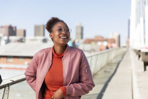 Black woman smiling wearing a pink jacket
