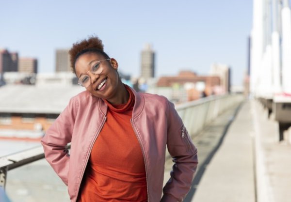 Black woman on Nelson Mandela bridge smiling with glasses