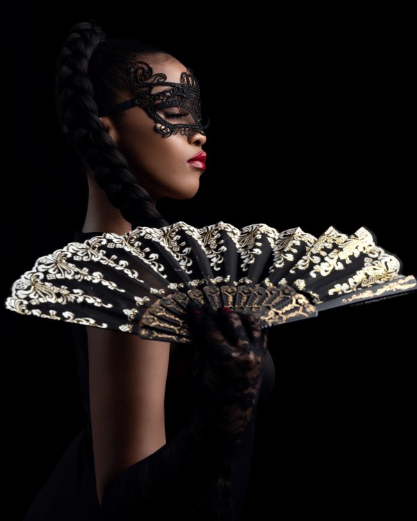 black woman posing in a masquerade mask