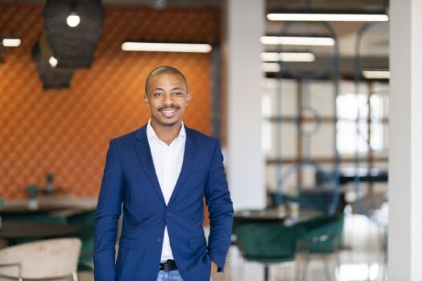 Black business man wearing a suit and smiling at the office