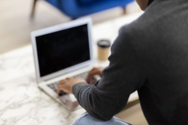 Black man working on his laptop with coffee