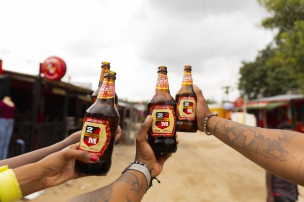 Black hands holding Mozambique beer.