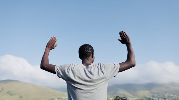 Black man praying in the mountains