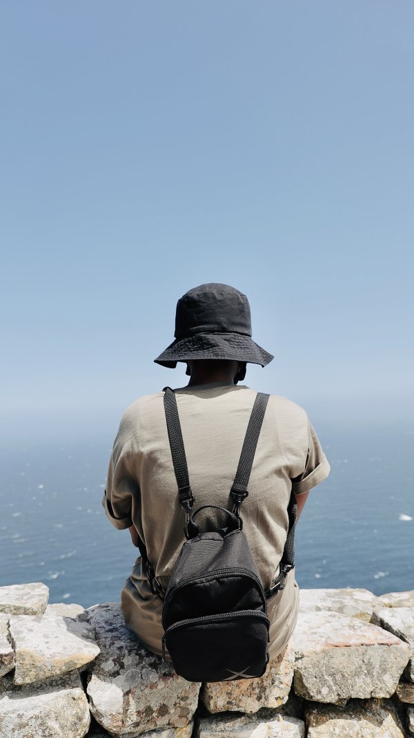 Black woman sitting by the ocean