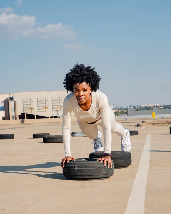 Black woman doing push-ups on a tyre