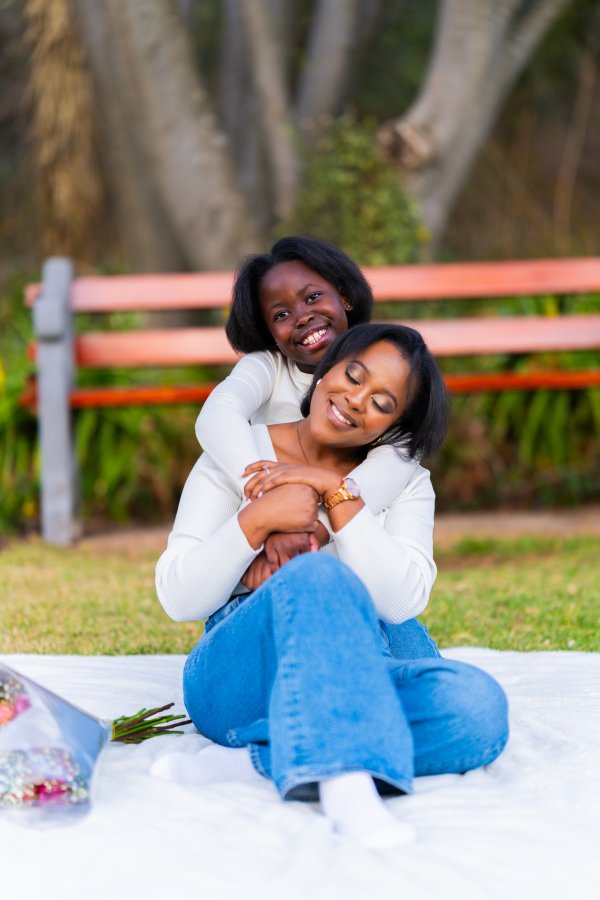 Happy mother and daughter at a park hugging each other