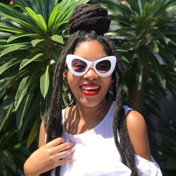 Black woman with white sunglasses smiling