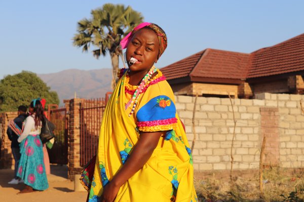 Tsonga woman dancing with a whistle in traditional attire