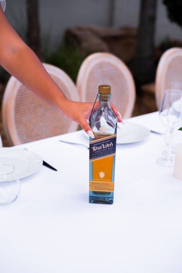 Johnny Walker Blue Label alcohol bottle with a woman hands holding it