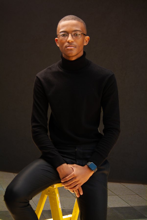 Black man sitting on a yellow ladder