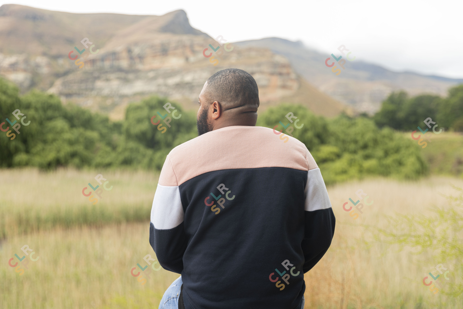Black man sitting watching the mountains