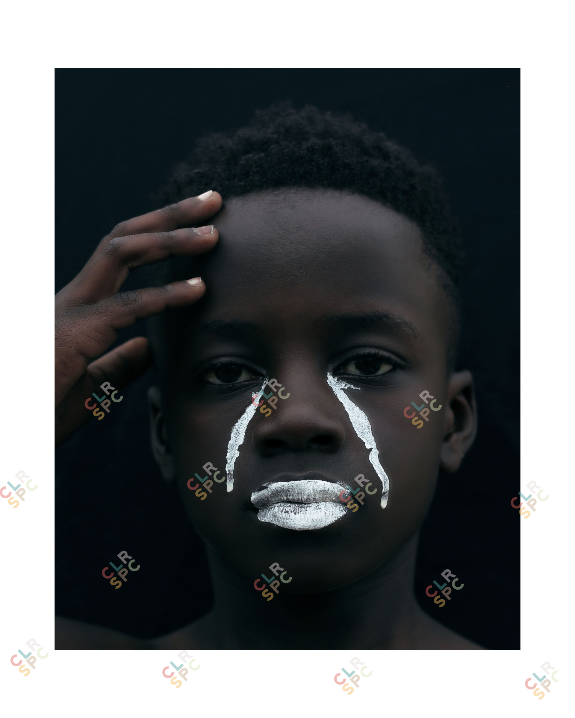 A portrait of a young black man in white tears