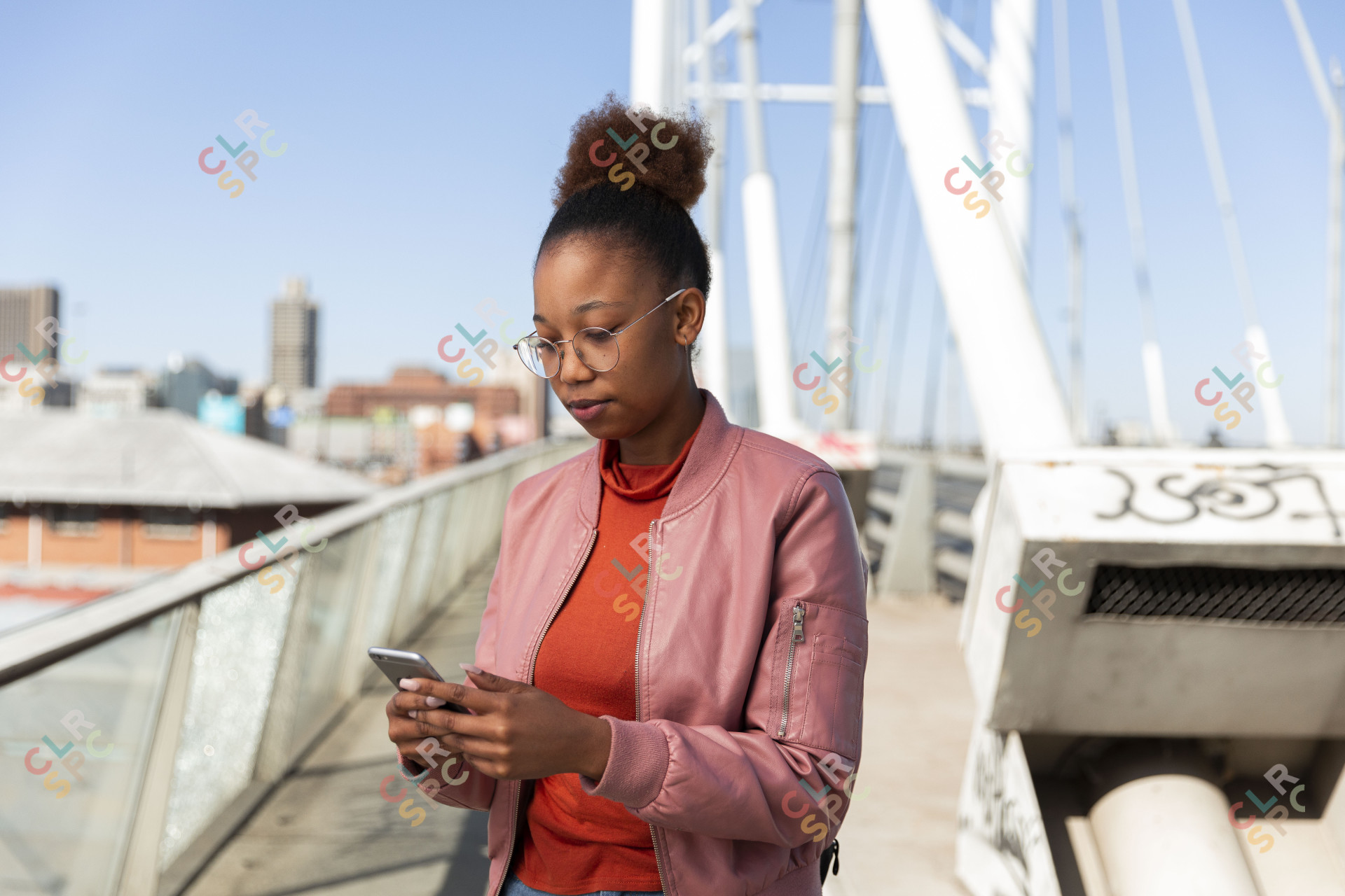 Black woman on a smartphone wearing a pink jacket.