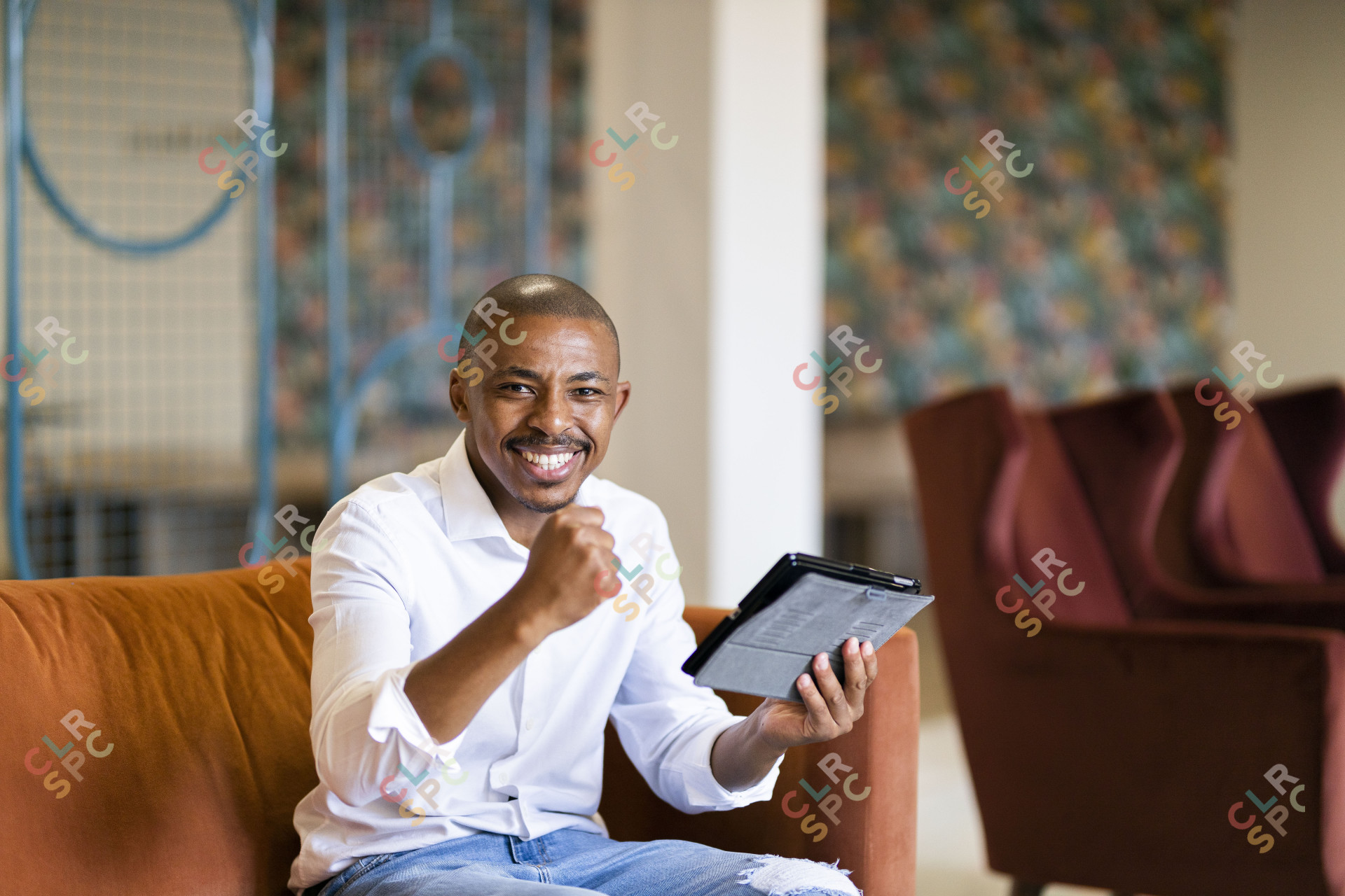 Black business man celebrating while looking at ipad
