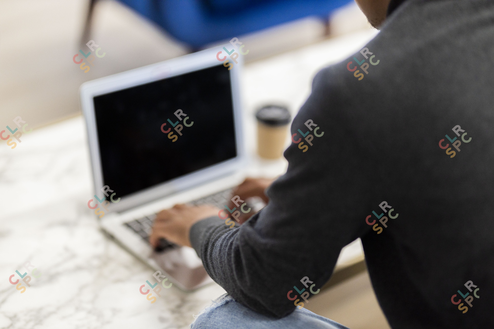 Black man working on his laptop with coffee