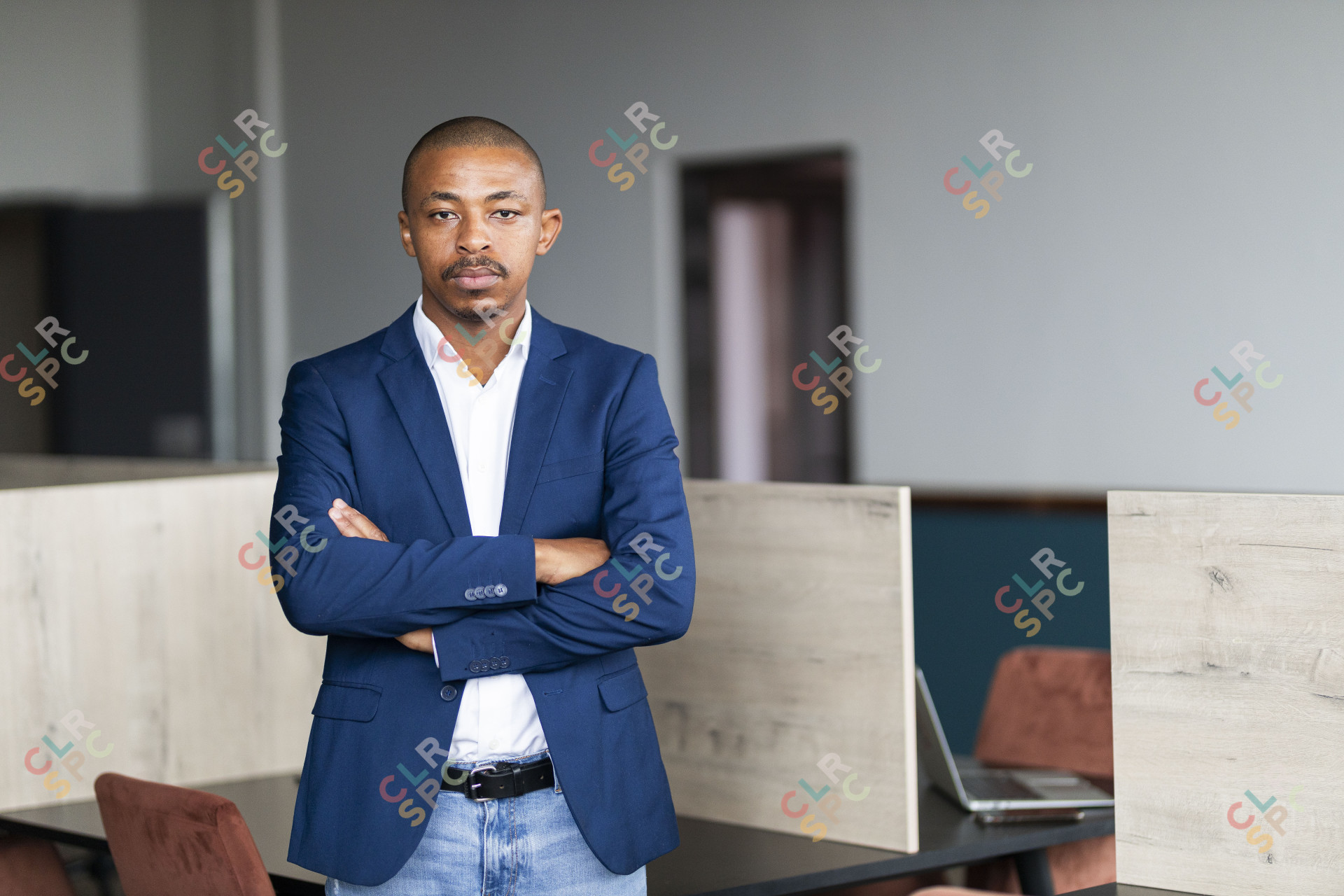 Black entrepreneur wearing a suit with folded arms