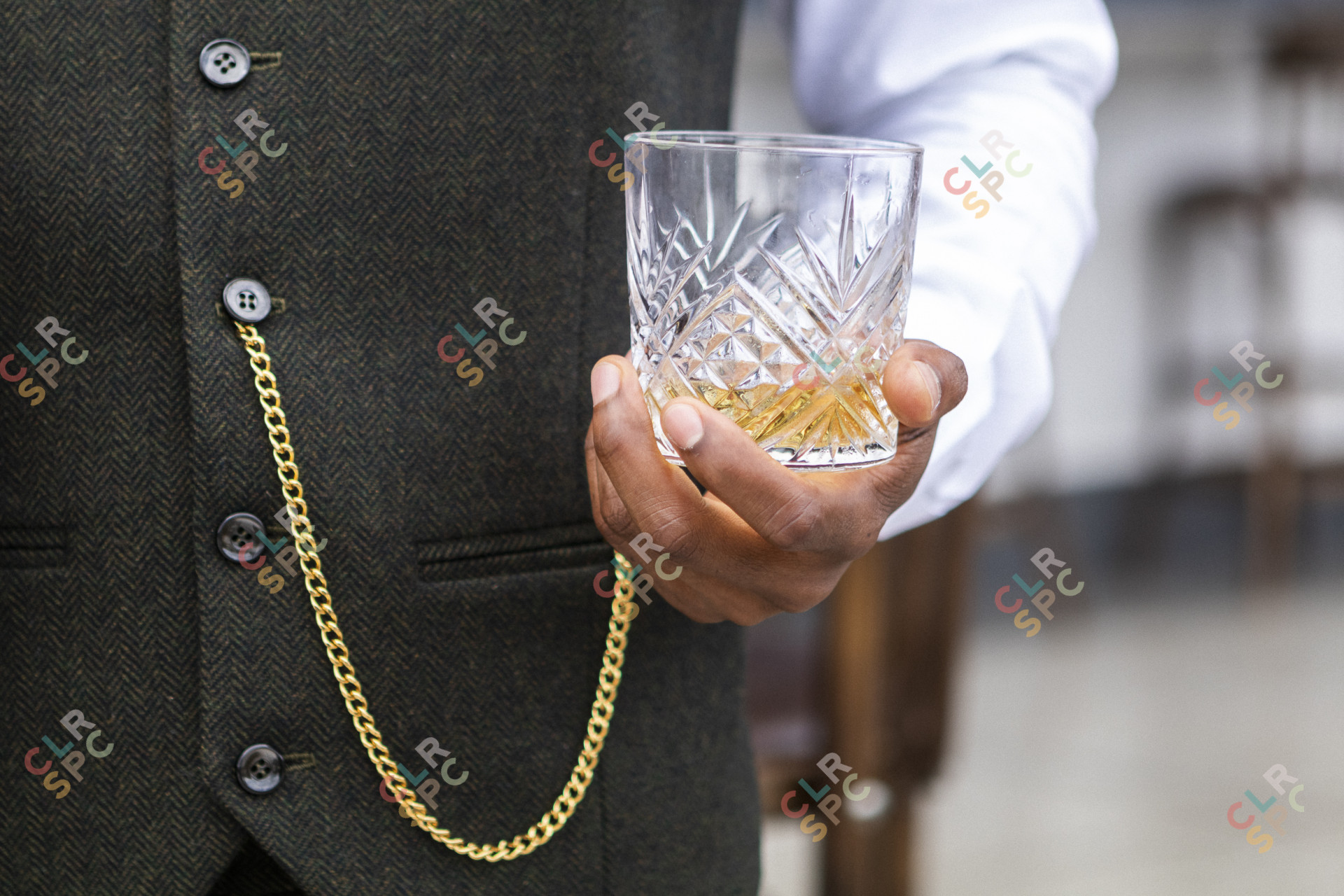 Black hands holding whisky glass