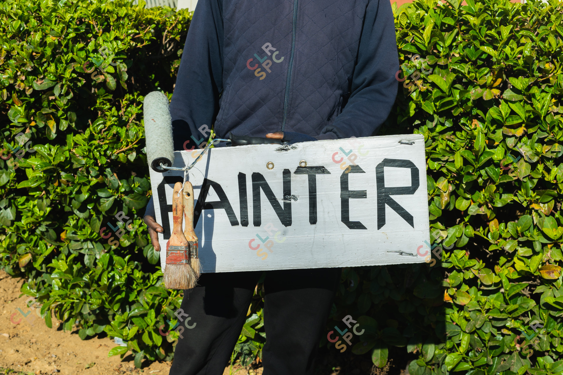 Jobless man holding a painter sign.