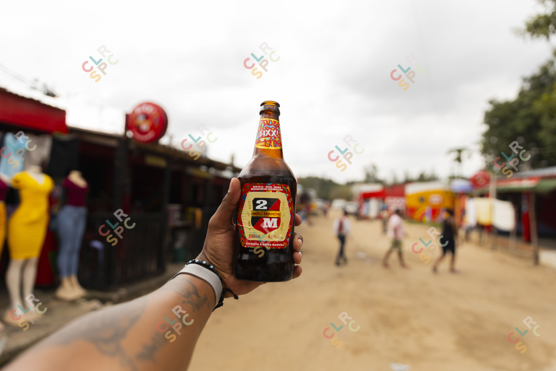 Black hand holding Mozambique beer in the air.