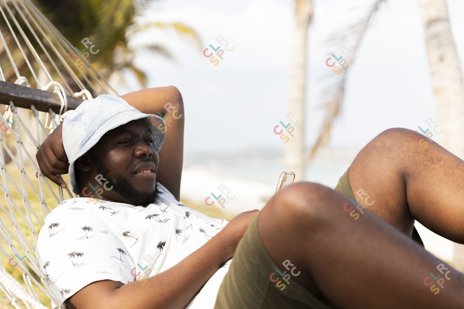Black man resting on a hammock.