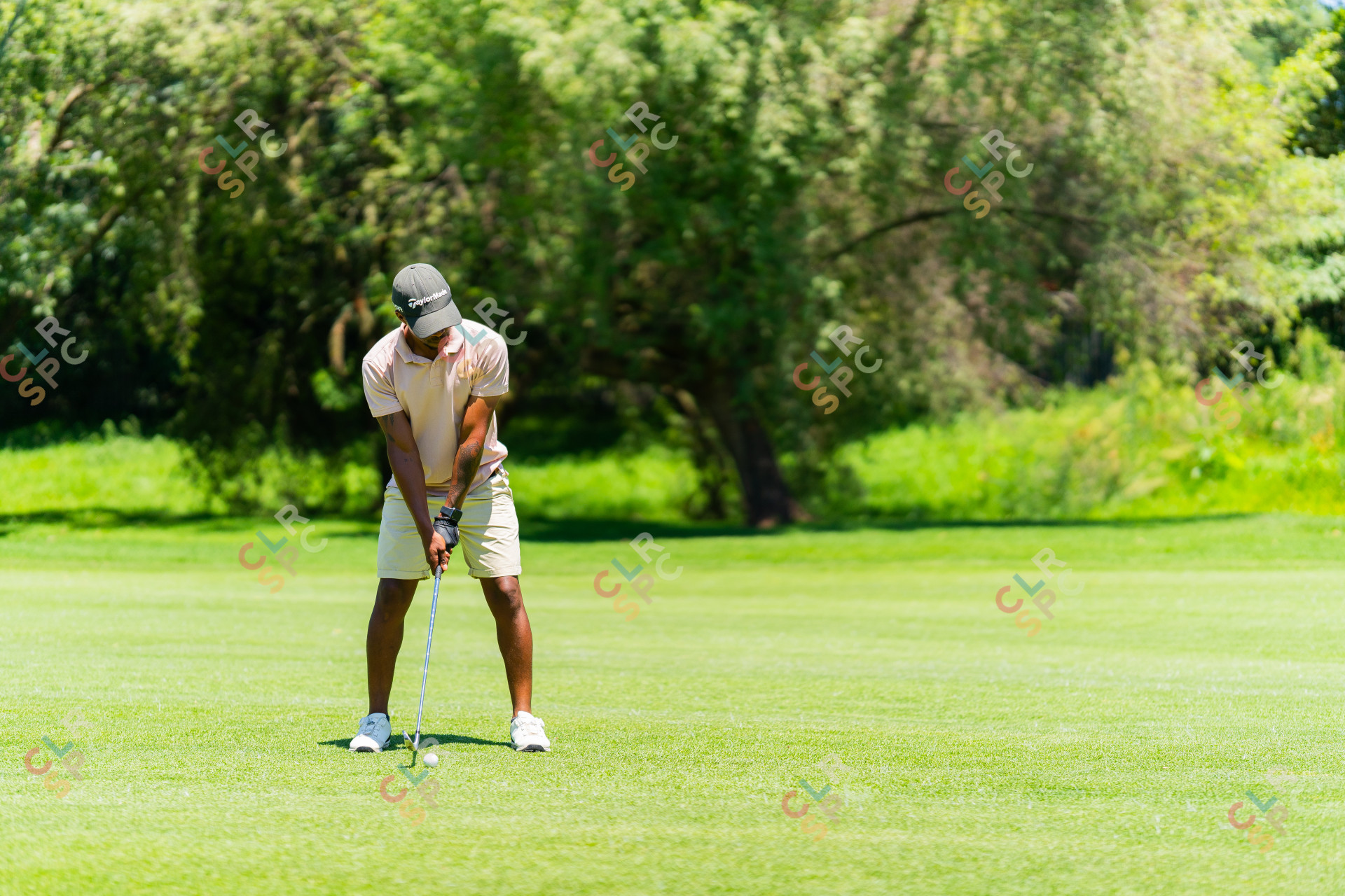 Black golfer wearing a pink shirt and a taylormade hat