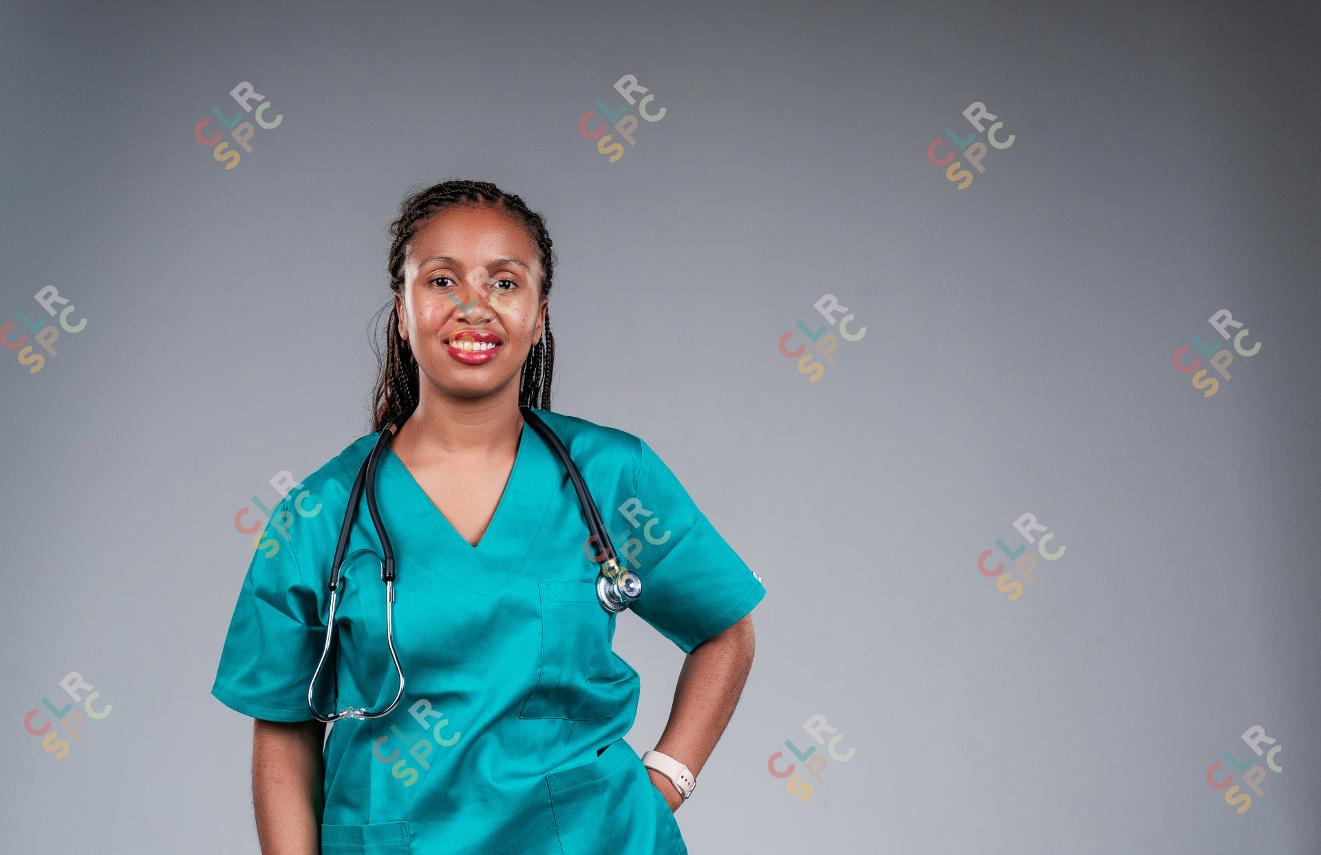 Portrait of happy medical doctor standing on grey background