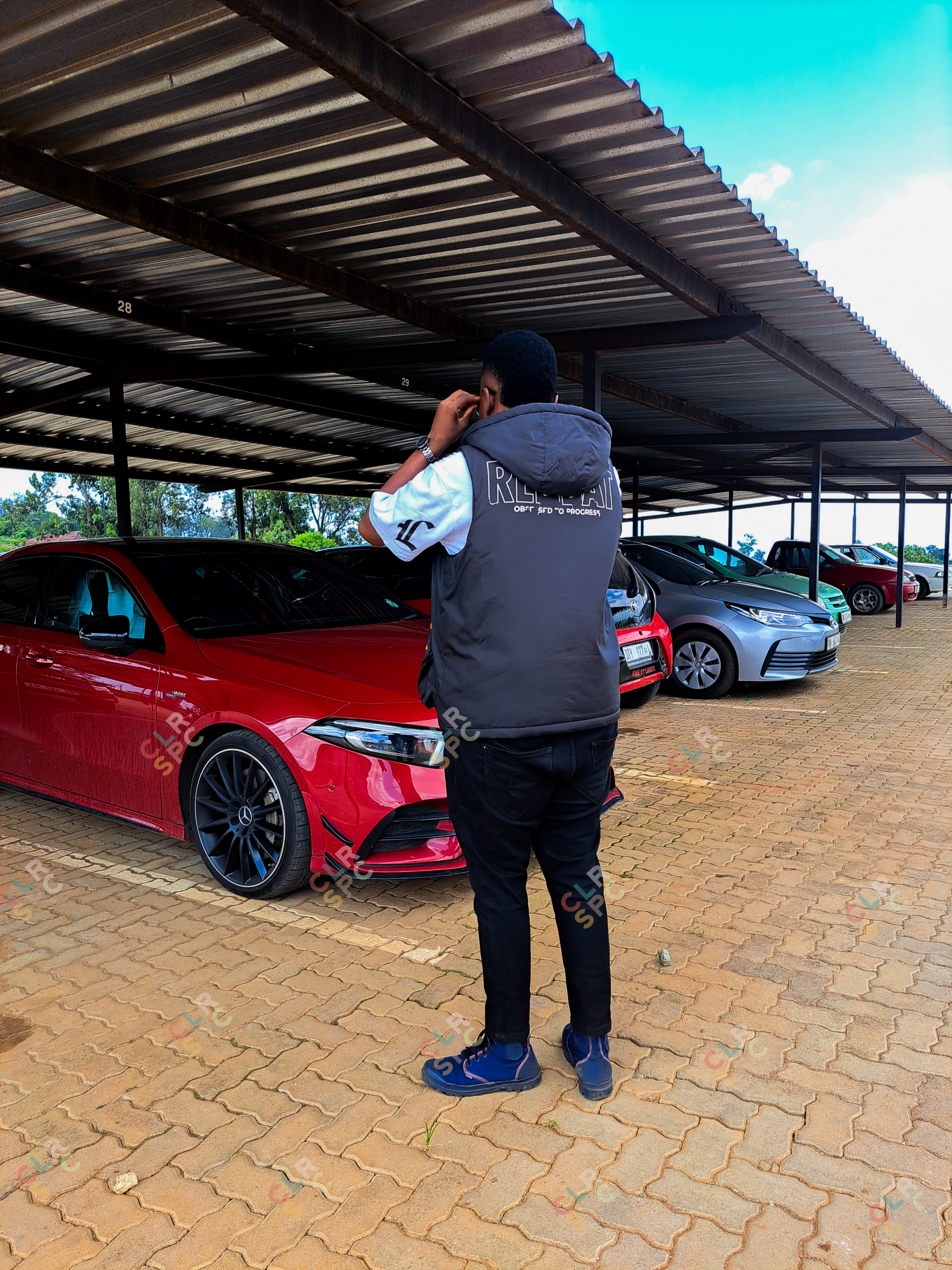 A PICTURE OF A YOUNG MAN ADMIRING THE BEAUTY OF THE MERCEDES BENZ VEHICLE