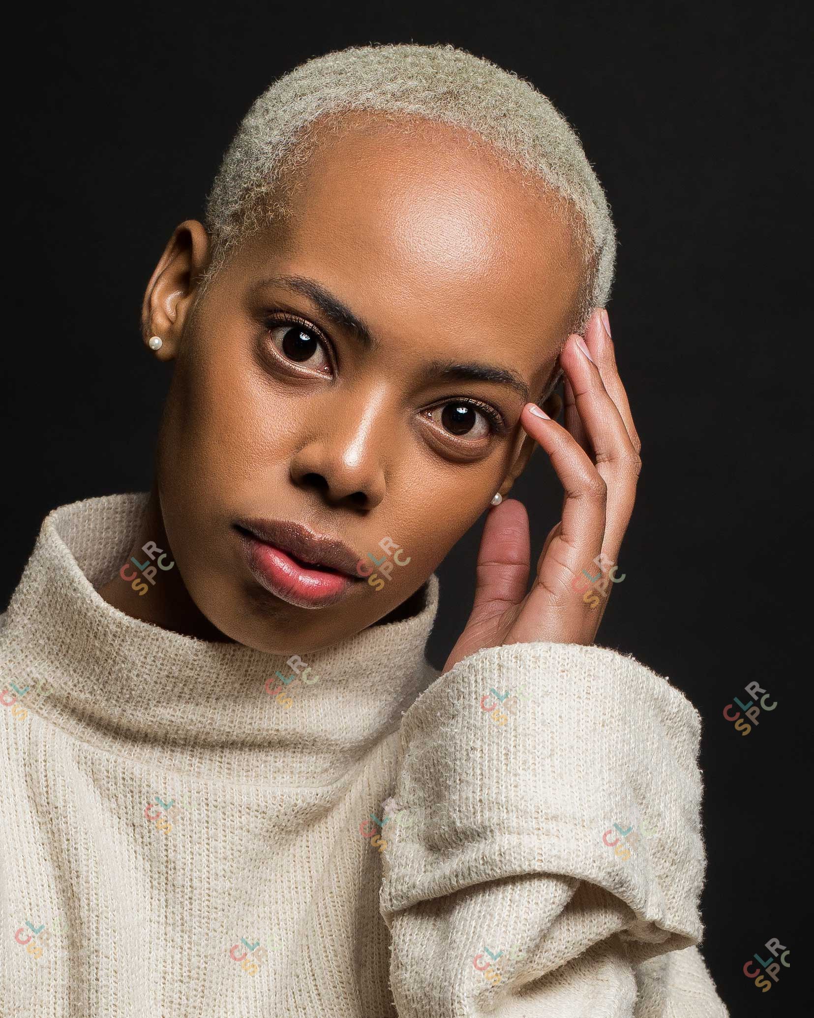 Black model posing in studio with a black backdrop