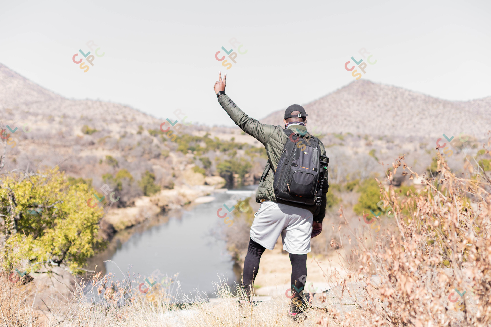 Black male holding peace sign in nature