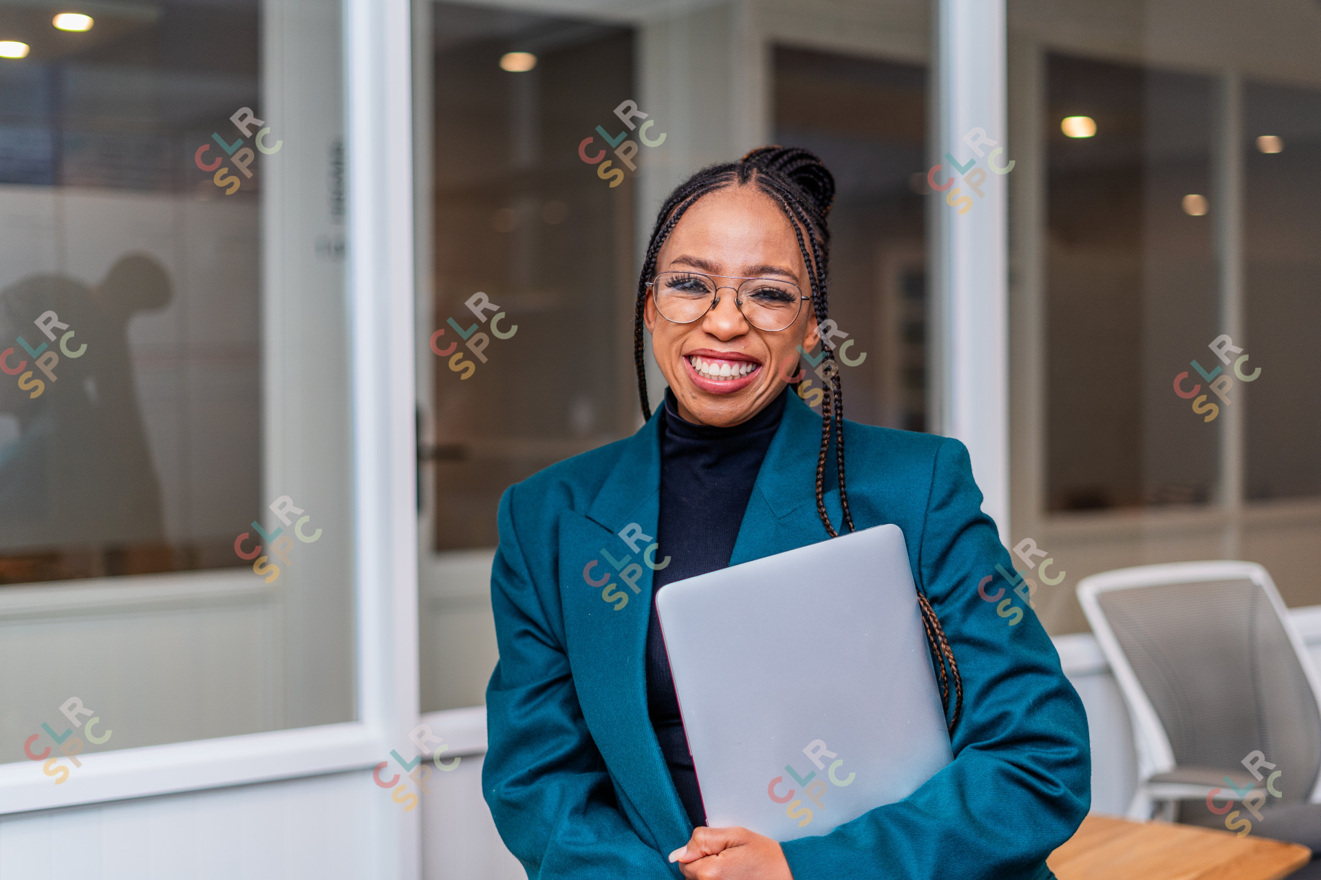 Young African Business woman holding a laptop smiling at the office.