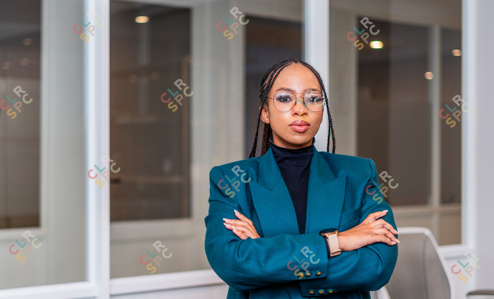 Young professional black woman wearing glasses with folded arms at the office.
