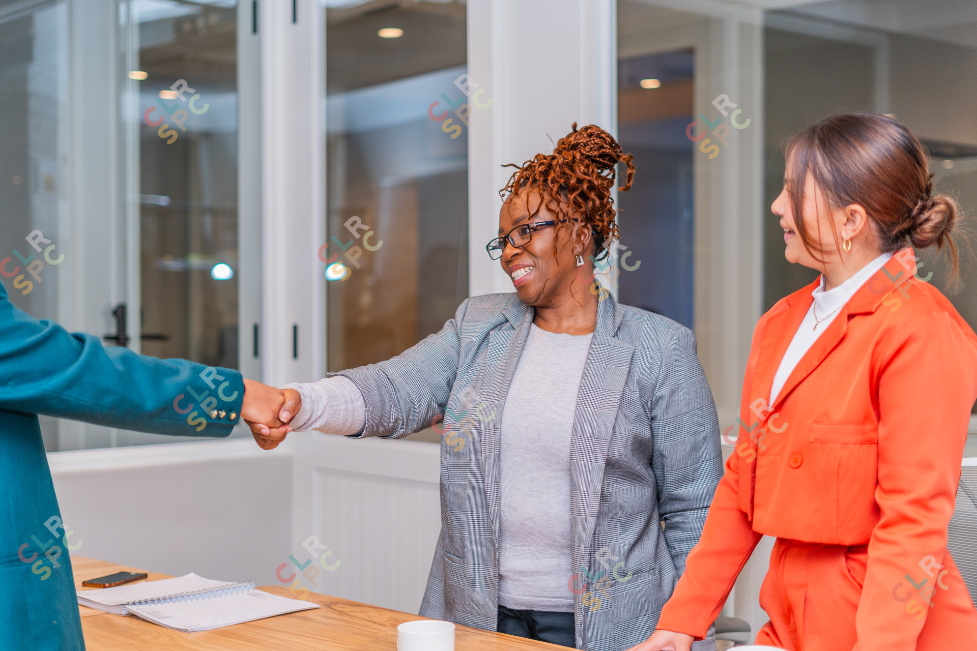 Smiling African woman manager shaking hands with a job applicant after an interview standing at a boardroom in an office.