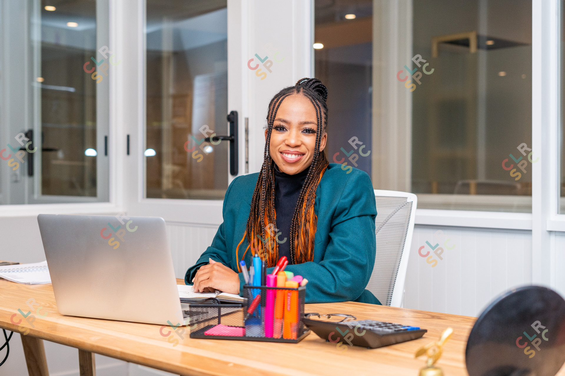 Smiling African black woman sitting at desk looking at the camera.