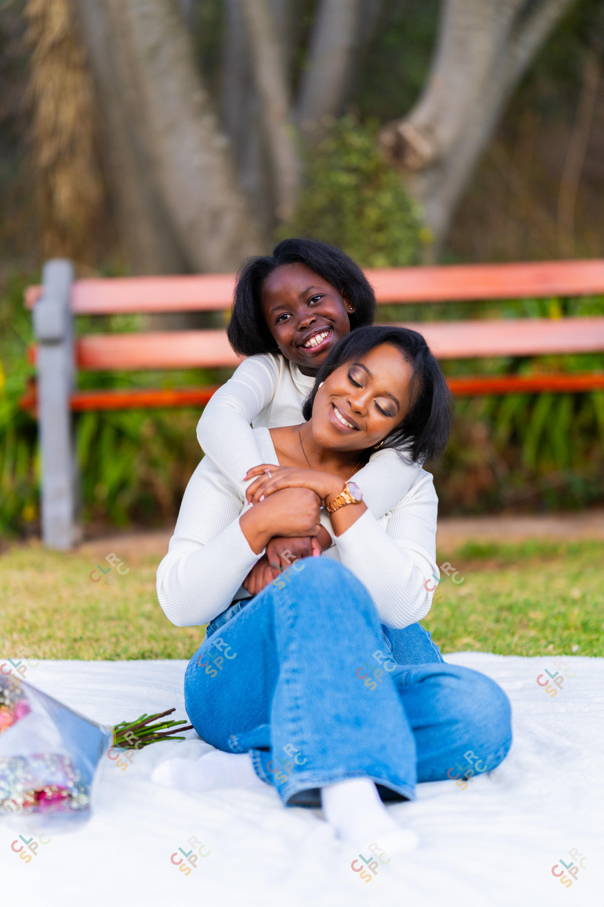 Happy mother and daughter at a park hugging each other