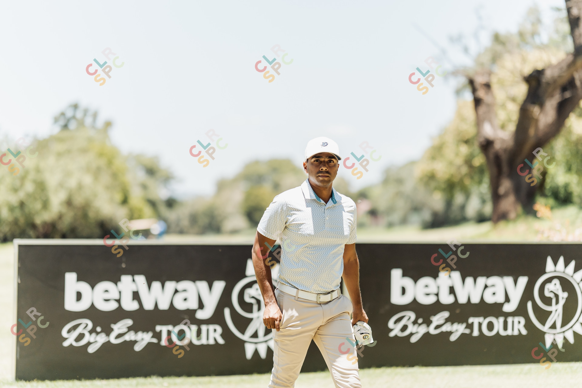 Golf player walking pass betray sign with glove in hand on a sunny day