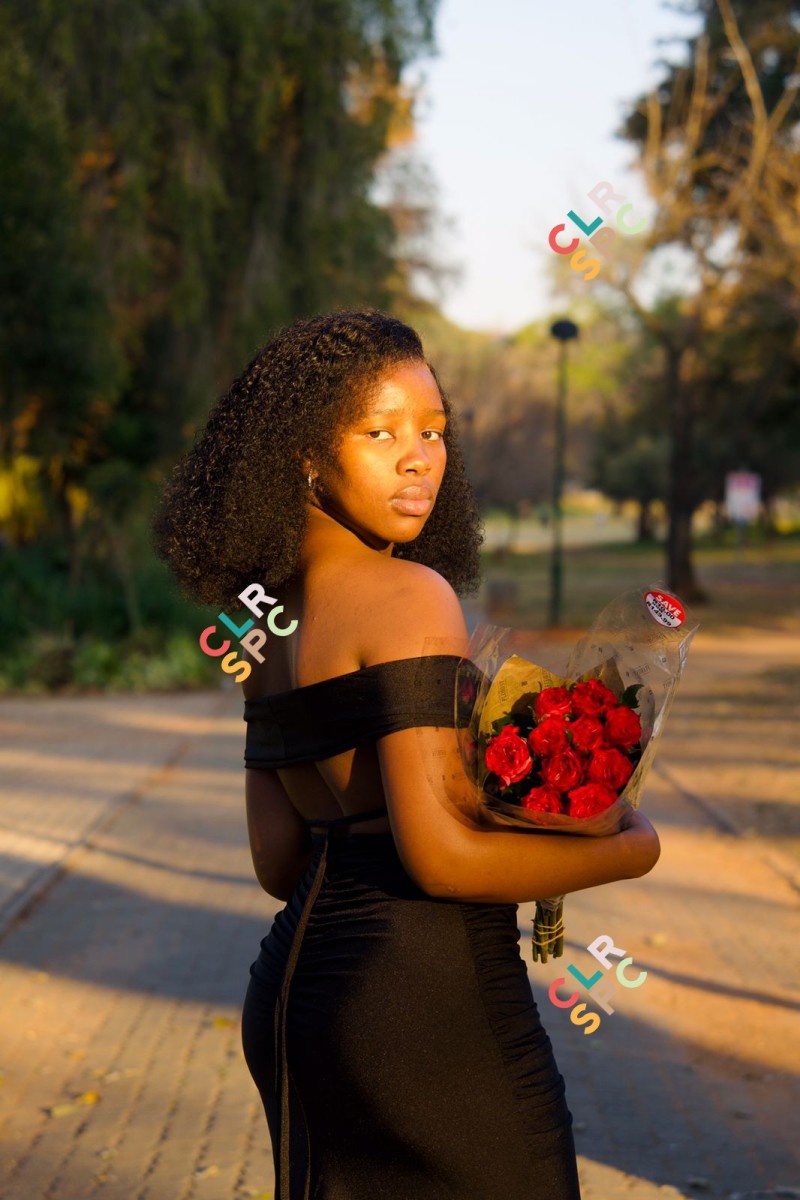 Beautiful black woman posing outside with red roses