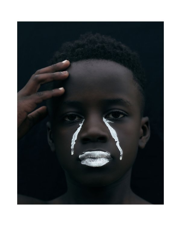 A portrait of a young black man in white tears